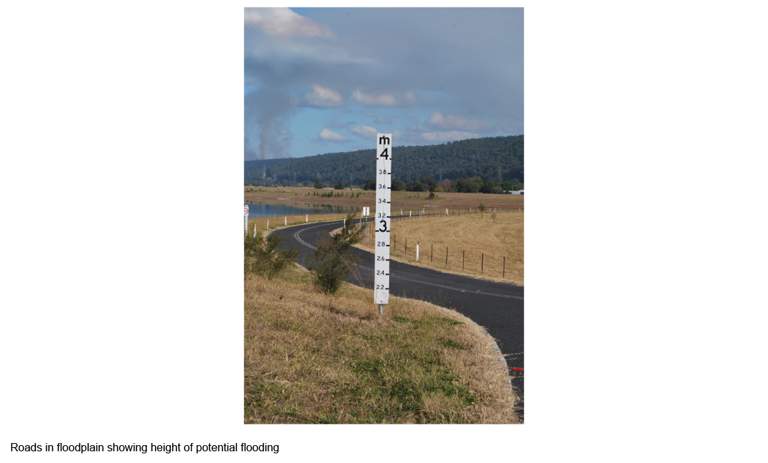 Roads in floodplain showing height of potential flooding sign