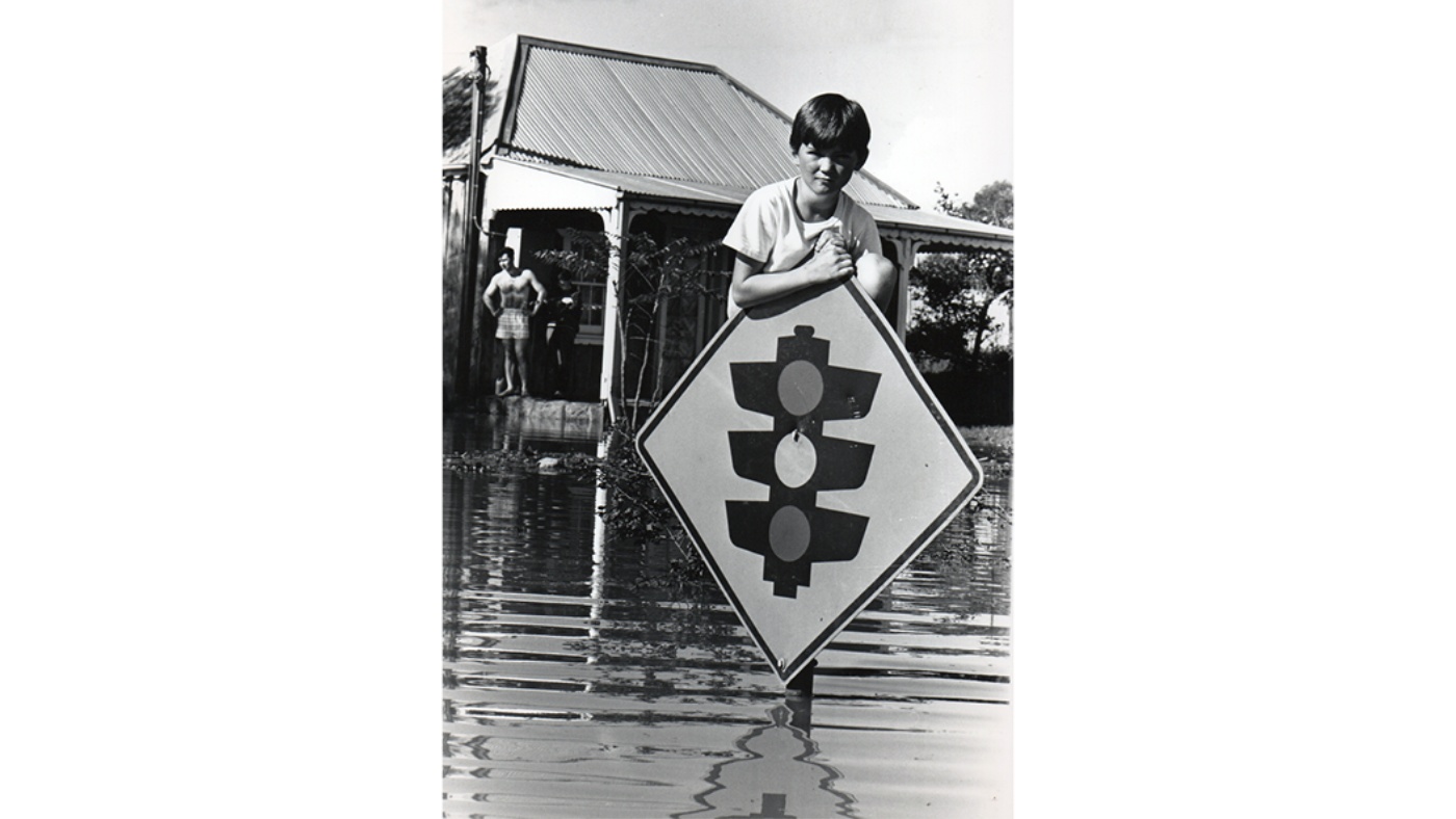 Damian Boyce, 9, clings to a traffic sign during Windsor floods, May 1 1988. Photo source: Newspix