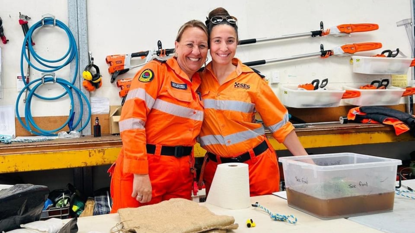 Two NSW SES volunteer standing together in a workshop