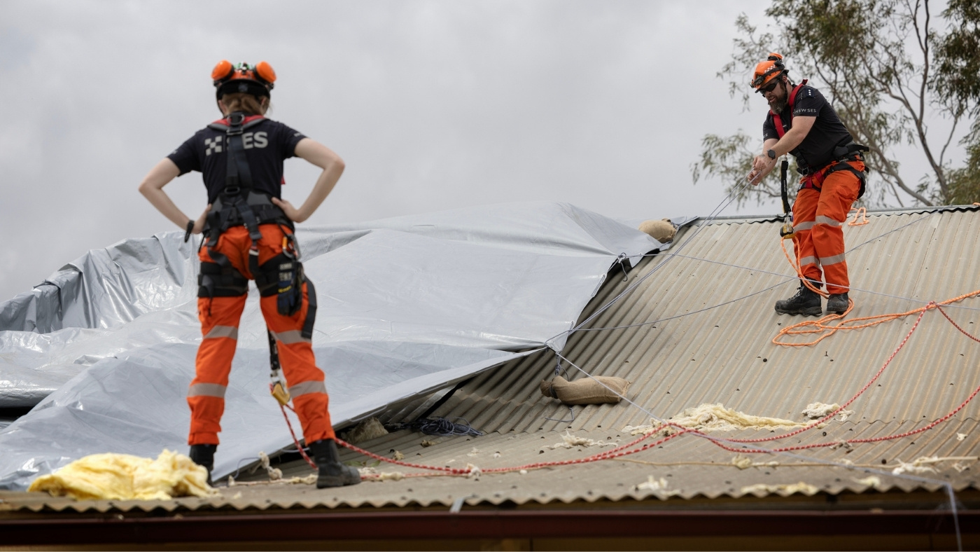 NSW SES Volunteer cleaning up a roof after a storm