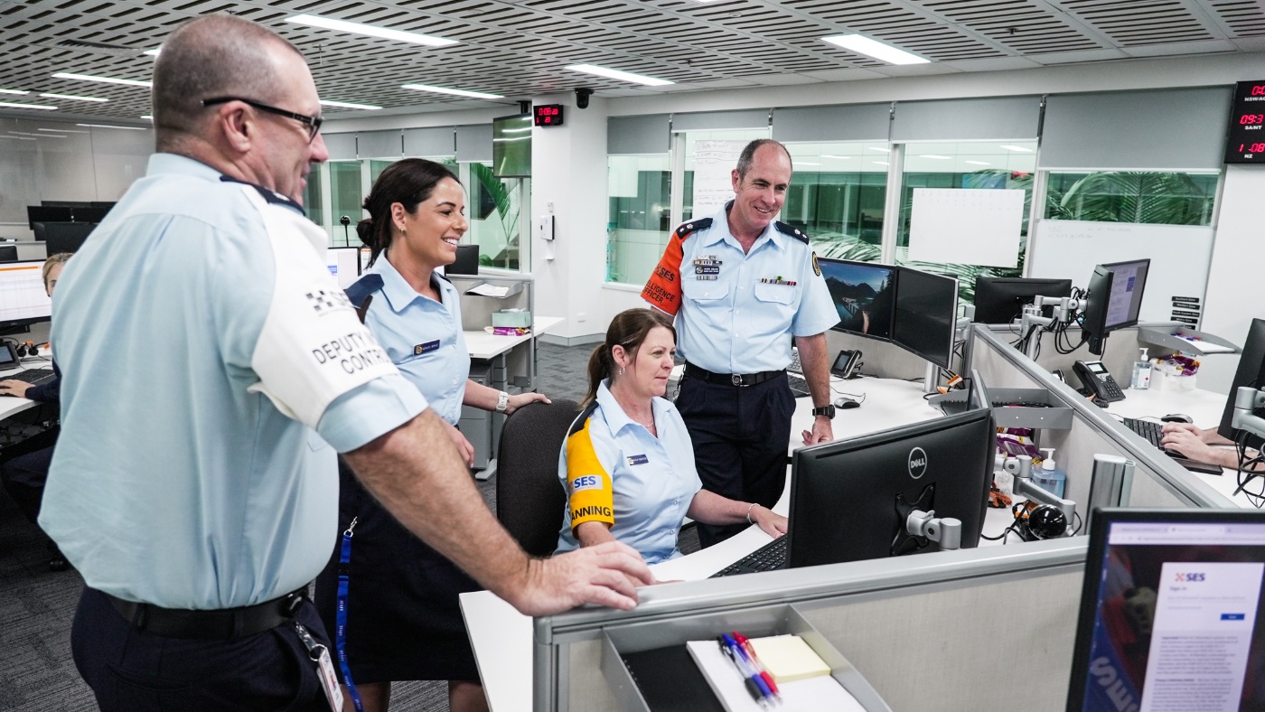 Four Incident Management Team members discussion over a desk