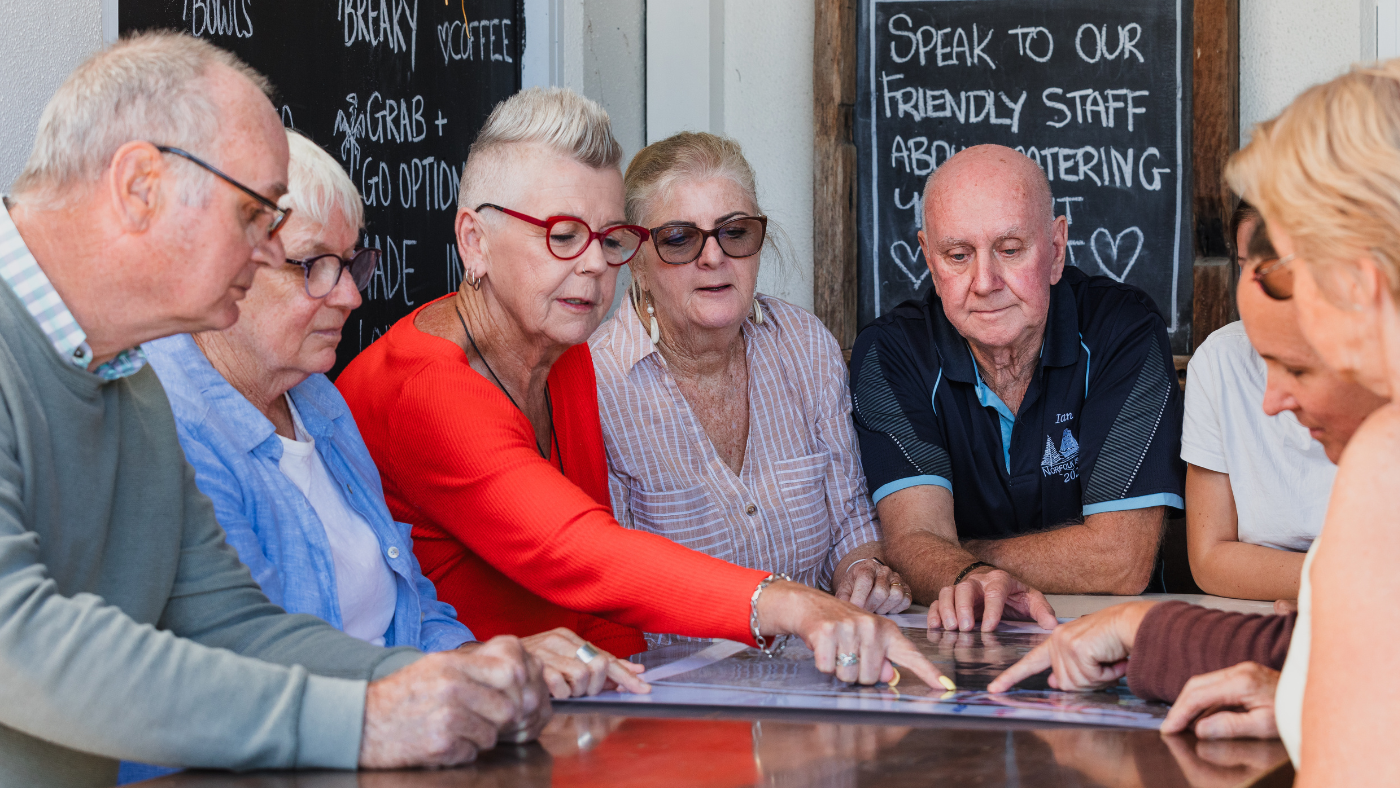 Group of community members gathering around a map